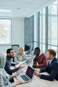 A diverse group of colleagues working together on a project in a bright, modern office environment.