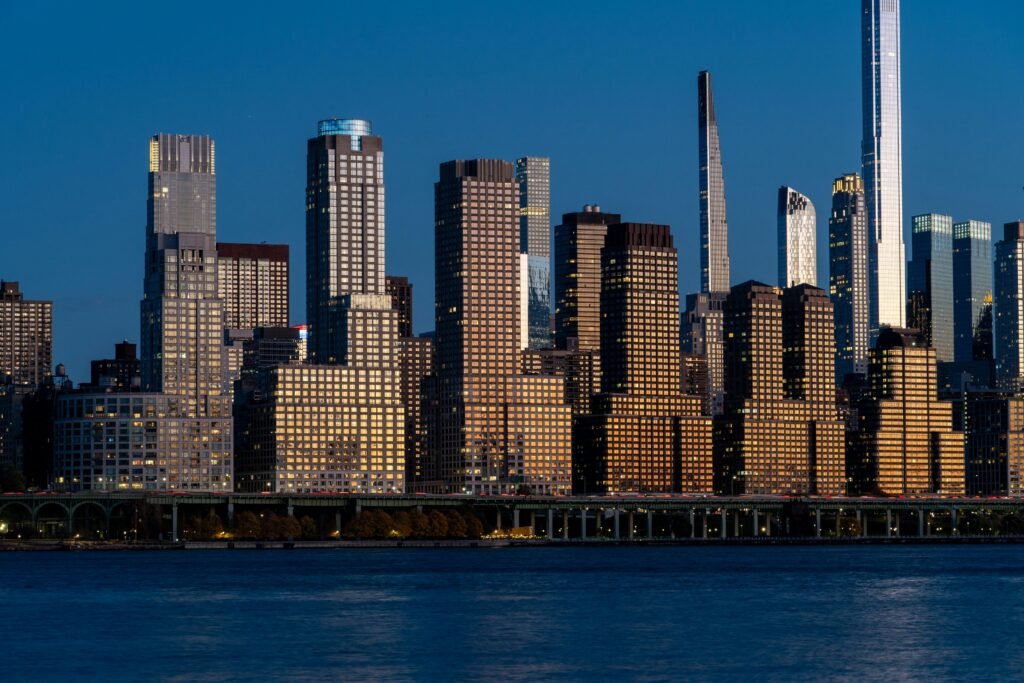 Breathtaking view of the New York City skyline reflecting the evening light against a clear blue sky.